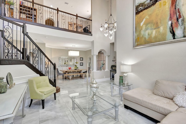 living area with visible vents, baseboards, an inviting chandelier, a towering ceiling, and stairs
