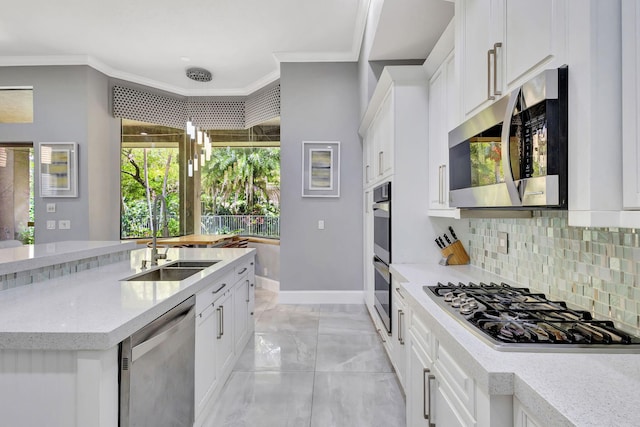 kitchen featuring white cabinets, stainless steel appliances, ornamental molding, and a sink