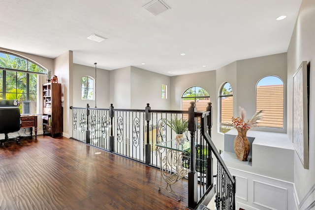 hallway with recessed lighting, an upstairs landing, visible vents, and wood finished floors