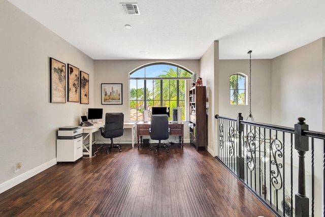 home office with wood finished floors, visible vents, and baseboards