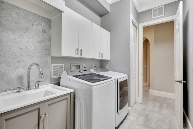 laundry area with a sink, visible vents, arched walkways, separate washer and dryer, and cabinet space