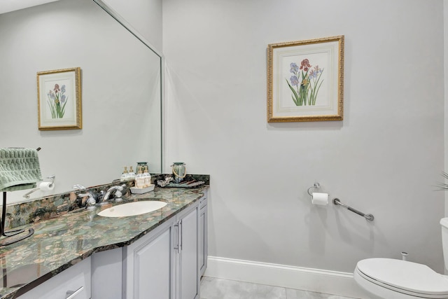 bathroom with vanity, toilet, marble finish floor, and baseboards