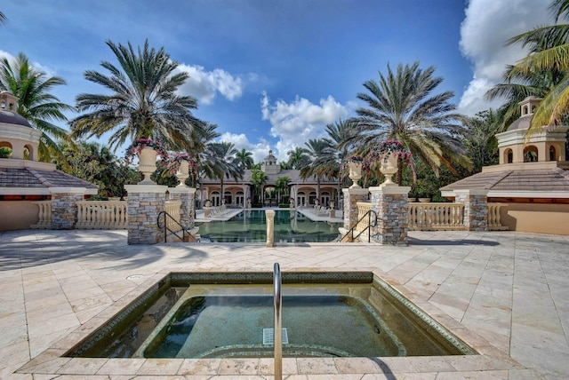 view of swimming pool featuring a patio area and a hot tub