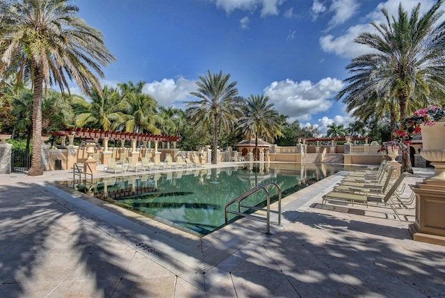 pool featuring fence and a patio area