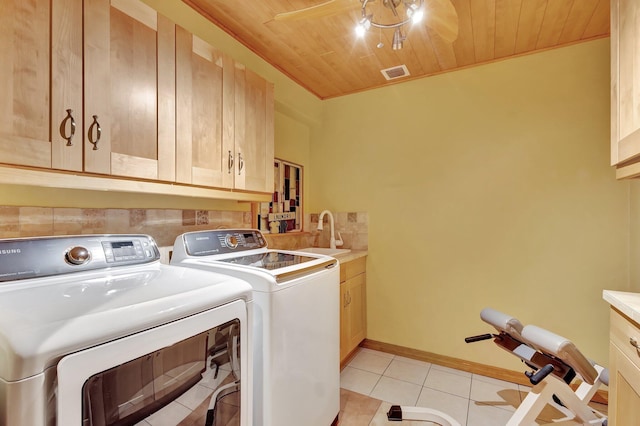 laundry area with a sink, cabinet space, light tile patterned flooring, visible vents, and washer and dryer