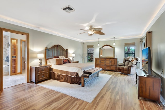 bedroom featuring visible vents, ornamental molding, ceiling fan, and light wood-style floors
