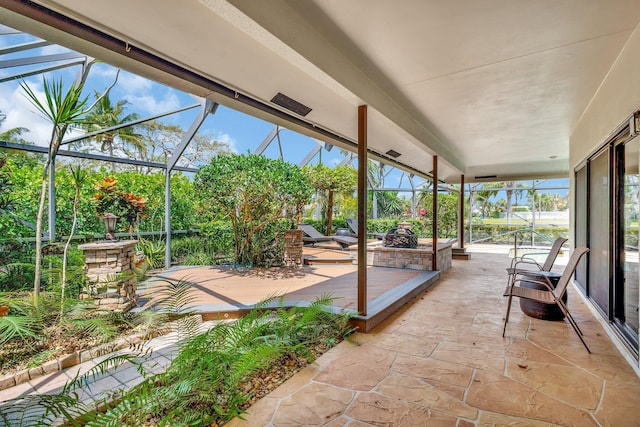 view of patio featuring a fire pit and a lanai