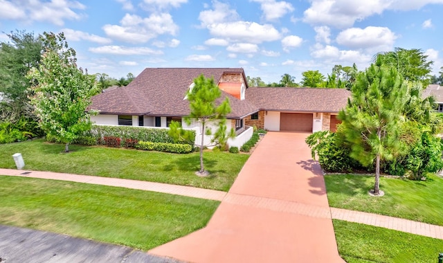 view of front of home with a garage, roof with shingles, driveway, and a front yard