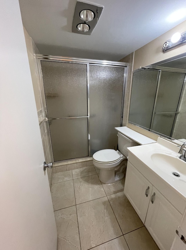 bathroom featuring a stall shower, toilet, and vanity