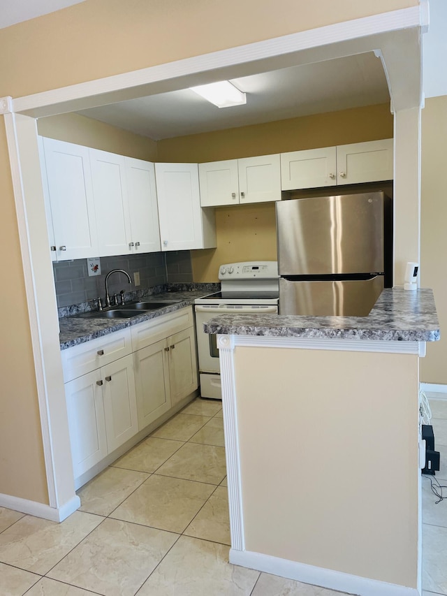 kitchen featuring a sink, white cabinets, white electric stove, and freestanding refrigerator
