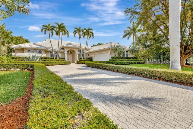 2465 Chesapeake Cir, West Palm Beach, FL 33409 - mediterranean / spanish-style home with decorative driveway, a garage, and stucco siding