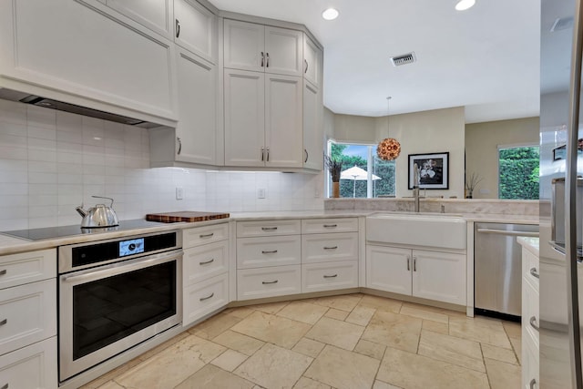 2465 Chesapeake Cir, West Palm Beach, FL 33409 - kitchen with a sink, appliances with stainless steel finishes, a healthy amount of sunlight, and visible vents