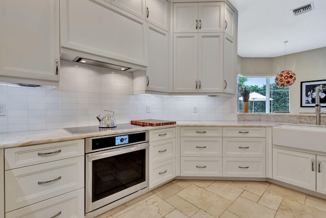 2465 Chesapeake Cir, West Palm Beach, FL 33409 - kitchen featuring visible vents, decorative backsplash, a sink, and stainless steel oven