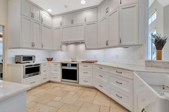 2465 Chesapeake Cir, West Palm Beach, FL 33409 - kitchen featuring appliances with stainless steel finishes, tasteful backsplash, and light stone counters