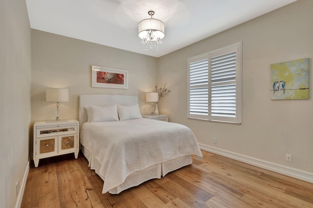 2465 Chesapeake Cir, West Palm Beach, FL 33409 - bedroom with baseboards, hardwood / wood-style flooring, and an inviting chandelier