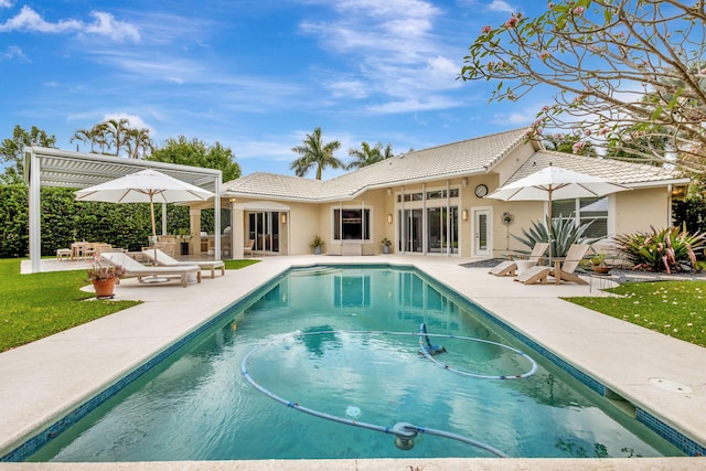2465 Chesapeake Cir, West Palm Beach, FL 33409 - rear view of property with stucco siding, a patio area, a tiled roof, and an outdoor pool