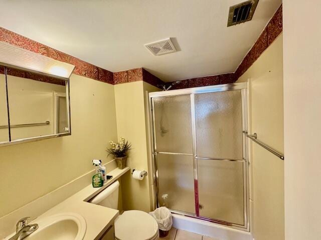 bathroom with a stall shower, toilet, and visible vents