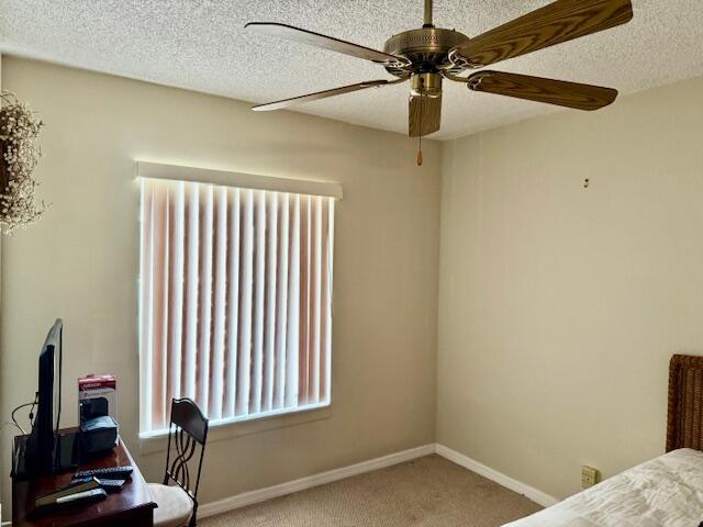 bedroom with baseboards, a textured ceiling, carpet, and ceiling fan