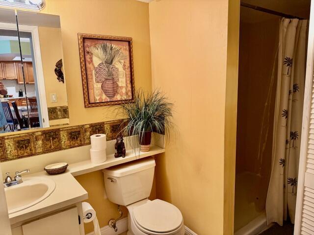 full bathroom featuring toilet, baseboards, curtained shower, and vanity