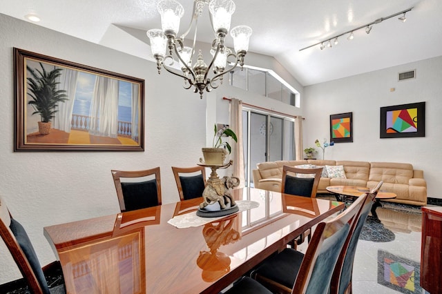 dining room with an inviting chandelier, visible vents, and lofted ceiling