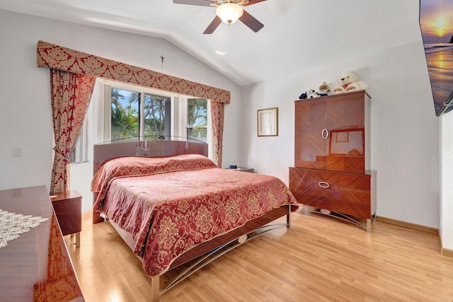 bedroom featuring a ceiling fan, baseboards, lofted ceiling, and light wood-style floors