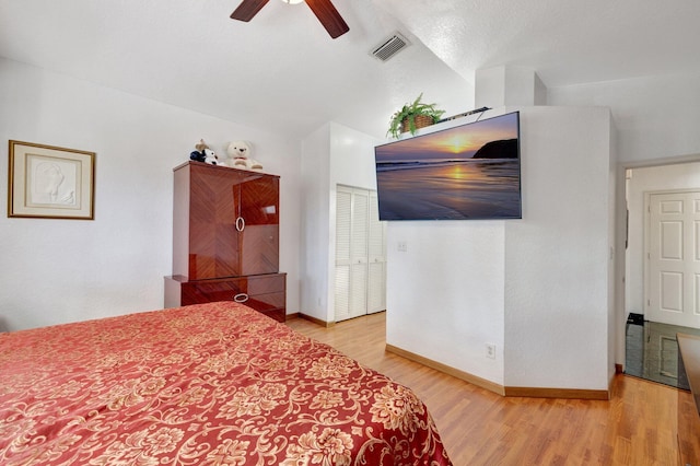 bedroom featuring visible vents, baseboards, wood finished floors, and vaulted ceiling