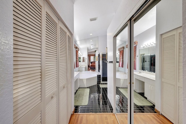 hall with visible vents and wood finished floors