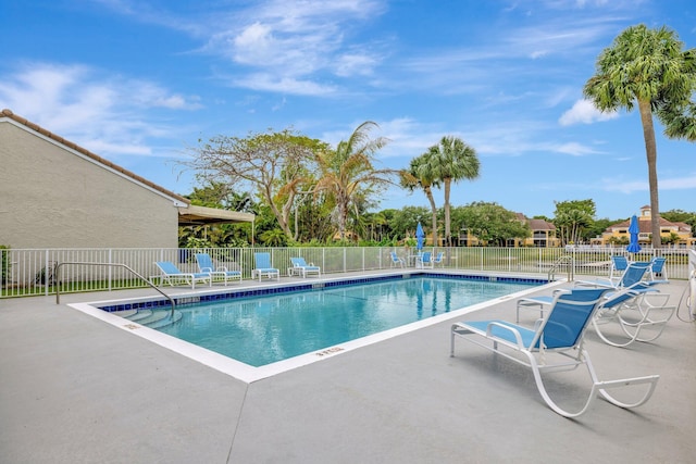 pool featuring fence and a patio area