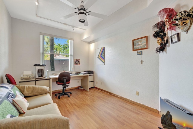 home office featuring a ceiling fan, baseboards, and light wood-style floors