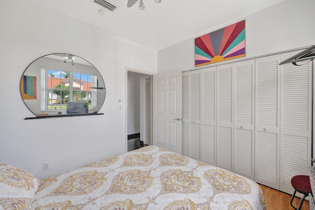 bedroom featuring a closet, wood finished floors, and visible vents