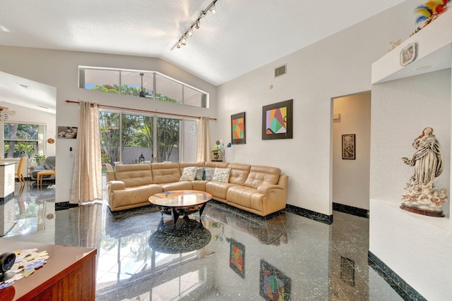 living room with track lighting, high vaulted ceiling, granite finish floor, baseboards, and visible vents