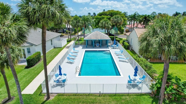 community pool featuring fence, a lawn, and a patio area