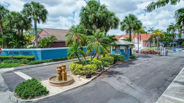 view of street featuring a gate, a gated entry, and curbs