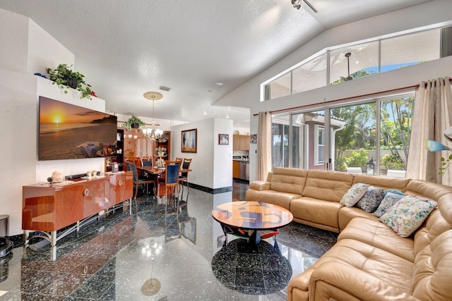 living room featuring visible vents, baseboards, a textured ceiling, granite finish floor, and a notable chandelier