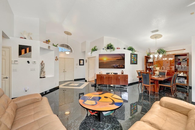 living area featuring visible vents, baseboards, granite finish floor, a notable chandelier, and vaulted ceiling