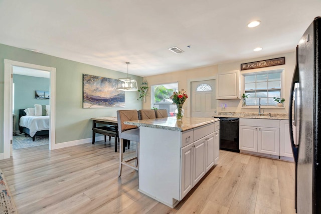 5810 Tucker Rd, Jupiter, FL 33458 - kitchen with black appliances, a sink, light wood finished floors, a center island, and recessed lighting