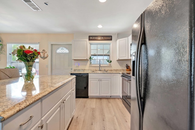 5810 Tucker Rd, Jupiter, FL 33458 - kitchen featuring black appliances, a sink, light wood-style flooring, white cabinetry, and recessed lighting
