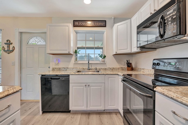 5810 Tucker Rd, Jupiter, FL 33458 - kitchen featuring black appliances, a sink, white cabinetry, light wood finished floors, and light stone counters