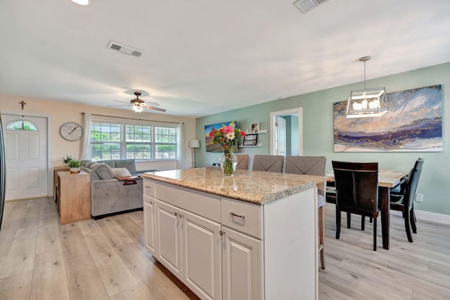 5810 Tucker Rd, Jupiter, FL 33458 - kitchen with light wood-type flooring, a center island, a ceiling fan, and pendant lighting