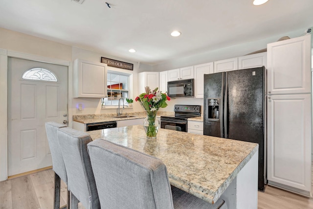 5810 Tucker Rd, Jupiter, FL 33458 - kitchen featuring black appliances, a sink, light countertops, light wood-style flooring, and recessed lighting