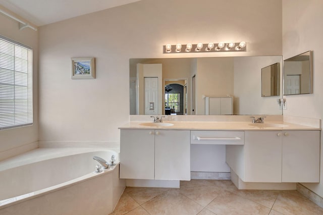 full bath featuring double vanity, tile patterned floors, a sink, and a garden tub