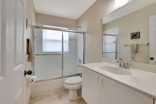 bathroom featuring vanity, bath / shower combo with glass door, tile patterned floors, and toilet