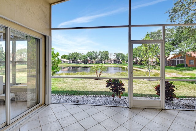 unfurnished sunroom with a water view and tile patterned flooring