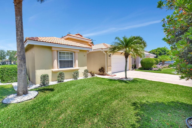 mediterranean / spanish home with an attached garage, a front lawn, stucco siding, concrete driveway, and a tiled roof
