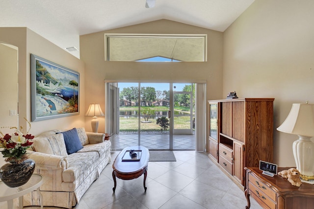 living room featuring light tile patterned floors and high vaulted ceiling