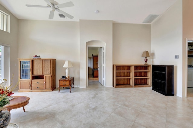 sitting room with arched walkways, a ceiling fan, light tile patterned flooring, and visible vents