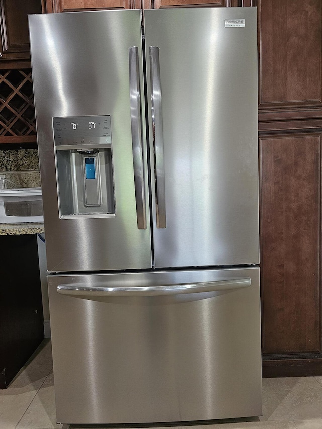 room details featuring dark brown cabinets and stainless steel fridge with ice dispenser