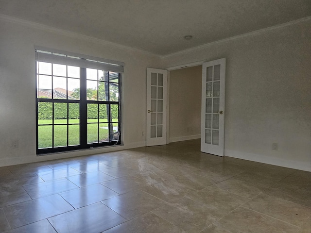 spare room featuring baseboards, ornamental molding, and french doors