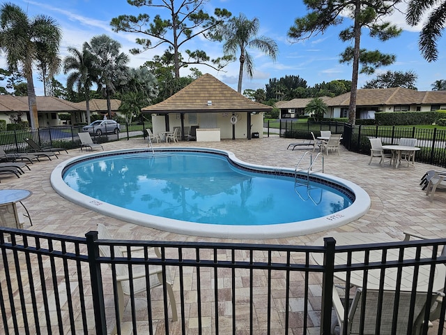 pool with fence and a patio