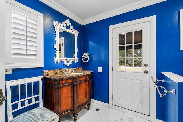 entryway with tile patterned floors, baseboards, ornamental molding, and a sink